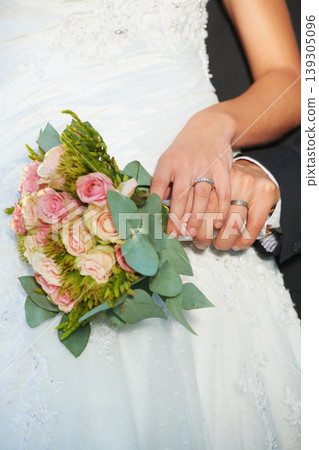 Couple, wedding ring and hands on rose bouquet in marriage with bride at celebration and event. Flower, loyalty and care with romance with love and commitment with woman and man and floral plant Couple, wedding ring and hands on rose bouquet in marriage with bride at celebration and event. Flower, loyalty and care with romance with love and commitment with woman and man and floral plant 139305096