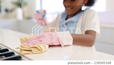 Happy girl, hands and cleaning table for housekeeping, hygiene or disinfection in chores at home. Closeup of female person, child or kid wipe surface, furniture or kitchen in bacteria or germ removal 139305100