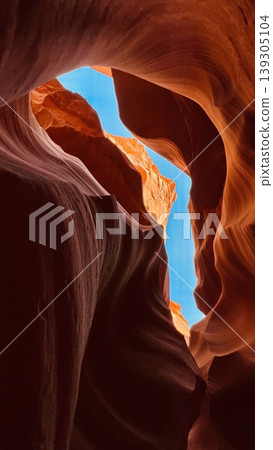 Sunlit Slot Canyon with Smooth Sandstone Walls and Blue Sky Sunlit Slot Canyon with Smooth Sandstone Walls and Blue Sky 139305104
