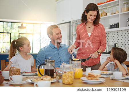 Food, breakfast and love with a family in the dining room of their home together for health or nutrition. Mother, father and sibling kids eating at a table in their apartment for morning bonding Food, breakfast and love with a family in the dining room of their home together for health or nutrition. Mother, father and sibling kids eating at a table in their apartment for morning bonding 139305109