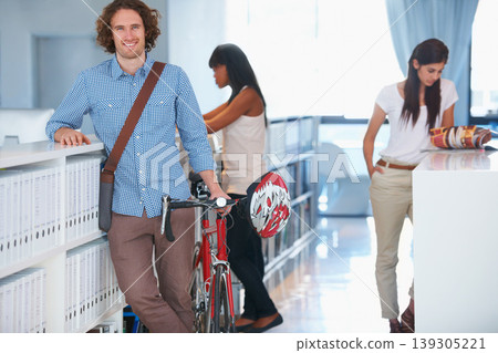 Smile, bicycle and portrait of businessman with team in the office for eco friendly transport with confidence. Happy, creative career and male designer from Canada with employees working in workplace Smile, bicycle and portrait of businessman with team in the office for eco friendly transport with confidence. Happy, creative career and male designer from Canada with employees working in workplace 139305221