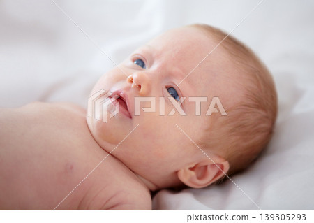 Face, growth and development with a baby on the bed of a home closeup for purity, innocence or wonder. Kids, curious and rest with a newborn infant child in the bedroom of an apartment from above Face, growth and development with a baby on the bed of a home closeup for purity, innocence or wonder. Kids, curious and rest with a newborn infant child in the bedroom of an apartment from above 139305293