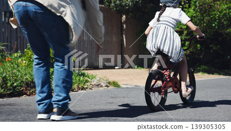 Dad, child and teaching bicycle ride for safety, outdoor street and having fun learning to cycle. Cycling, childhood memory and riding in summer with helmet, bonding together and recreation activity 139305305