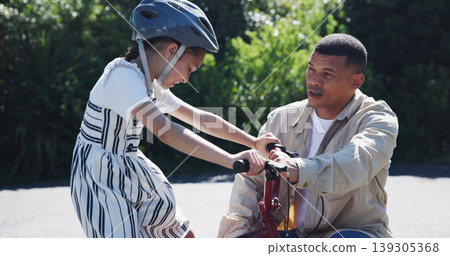 Bike, learning and child or help from dad, teaching and cycling in neighbourhood, helmet and safety. Daughter, father and support or fun, skill development and growth on road, trust and outdoors Bike, learning and child or help from dad, teaching and cycling in neighbourhood, helmet and safety. Daughter, father and support or fun, skill development and growth on road, trust and outdoors 139305368