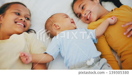 Love, family and sisters with baby boy on a bed for bonding, relax and conversation at home together. Happy, care and girl children lying with little brother in a bedroom with comfort and security Love, family and sisters with baby boy on a bed for bonding, relax and conversation at home together. Happy, care and girl children lying with little brother in a bedroom with comfort and security 139305380