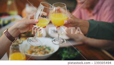 Lunch. closeup and people with juice, cheers and dining room with fruit beverage, relax and wellness. Family, home and hands drink with health, nutrition meal and toast with celebrate and relaxing Lunch. closeup and people with juice, cheers and dining room with fruit beverage, relax and wellness. Family, home and hands drink with health, nutrition meal and toast with celebrate and relaxing 139305494