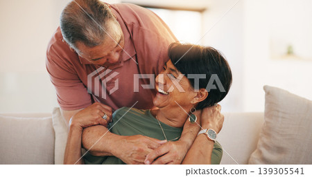 Mature, man and woman with smile for embrace in living room on sofa for love, care or romance in relationship. Happy couple, together or married in laugh by funny joke, memory or conversation in home Mature, man and woman with smile for embrace in living room on sofa for love, care or romance in relationship. Happy couple, together or married in laugh by funny joke, memory or conversation in home 139305541