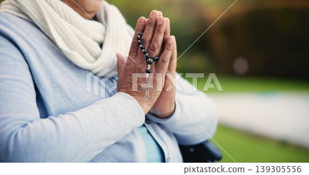 Senior, woman or hands praying with rosary for religion, worship and support for jesus christ in garden of home. Elderly, person and prayer beads for thank you, gratitude and trust in God for praise 139305556