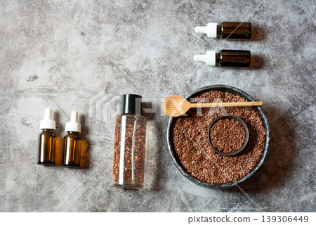 Flaxseed Oil and Seeds in Glass Bottles and Bowl on Gray Background Flaxseed Oil and Seeds in Glass Bottles and Bowl on Gray Background 139306449