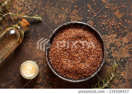 Flaxseeds in Bowl with Oil and Butter on Rustic Table Flaxseeds in Bowl with Oil and Butter on Rustic Table 139306457