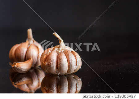 Fresh Garlic Bulbs and Cloves on Reflective Surface 139306487