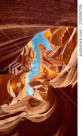 Sunlit Slot Canyon with Smooth Sandstone Walls and Blue Sky 139306706