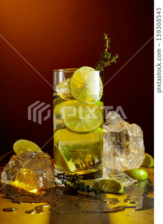 Cold refreshing drink with ice and lime in tall glass with water condensation drops. Cold refreshing drink with ice and lime in tall glass with water condensation drops. 139308545