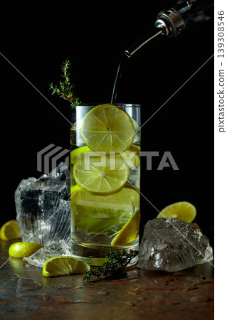 Cold refreshing drink with ice and lime in tall glass with water condensation drops. Cold refreshing drink with ice and lime in tall glass with water condensation drops. 139308546