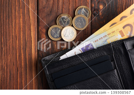 Leather Wallet with Cards, Euro Cash and Coins on Dark Wooden Background Leather Wallet with Cards, Euro Cash and Coins on Dark Wooden Background 139308567