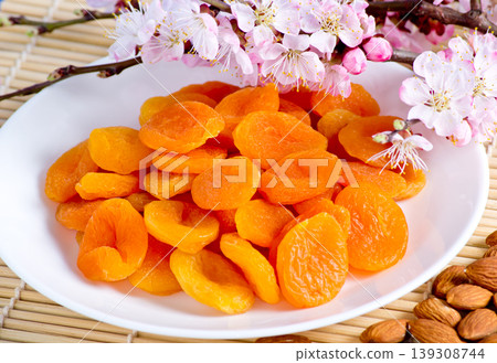 Dried apricots with almonds and blossoming branch Dried apricots with almonds and blossoming branch 139308744