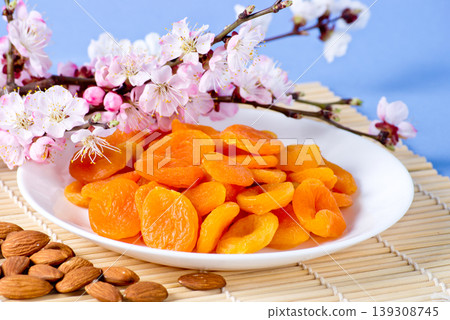 Dried apricots with almonds and blossoming branch Dried apricots with almonds and blossoming branch 139308745