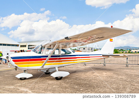 Single engine ultralight airplane waiting to take off at the airfield with blue sky and field background Single engine ultralight airplane waiting to take off at the airfield with blue sky and field background 139308789