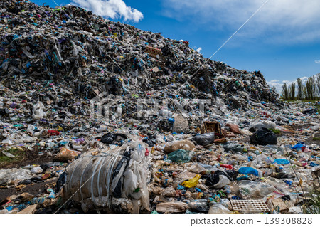 Large piles of waste and plastic cover a landfill site. The scene shows pollution and the impact of waste management practices Large piles of waste and plastic cover a landfill site. The scene shows pollution and the impact of waste management practices 139308828