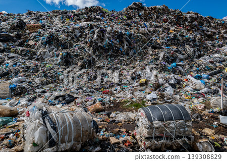 Large piles of mixed waste including plastic and organic materials in an urban setting in daylight 139308829
