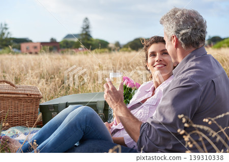 Mature, couple relax and picnic in park on date with love, care or support in marriage. Outdoor, man and woman on grass in nature with drink, flowers or celebration in summer, holiday or vacation Mature, couple relax and picnic in park on date with love, care or support in marriage. Outdoor, man and woman on grass in nature with drink, flowers or celebration in summer, holiday or vacation 139310338