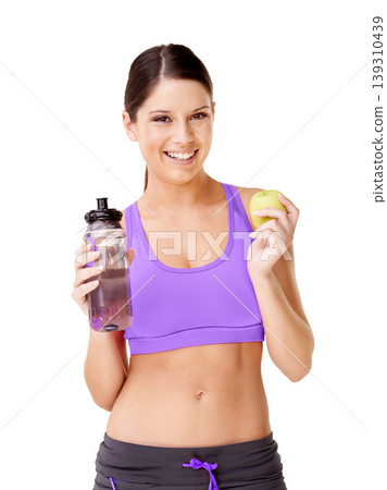 Woman, apple and water bottle in studio for healthy food choice, wellness and diet on a white background. Portrait of young model or vegan person with green fruit and liquid for detox or weight loss 139310439