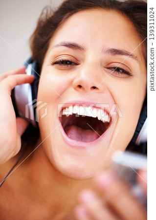 Music headphones, portrait and happy woman singing, excited and streaming track, audio podcast or playlist sound. Closeup shouting face, energy and singer voice, noice and listen to radio player 139311024
