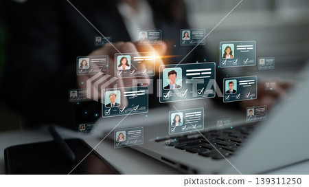 A professional actively engages with a digital interface displaying people profiles, highlighting modern business communication and selection processes in a contemporary office environment. Sigmoid A professional actively engages with a digital interface displaying people profiles, highlighting modern business communication and selection processes in a contemporary office environment. Sigmoid 139311250