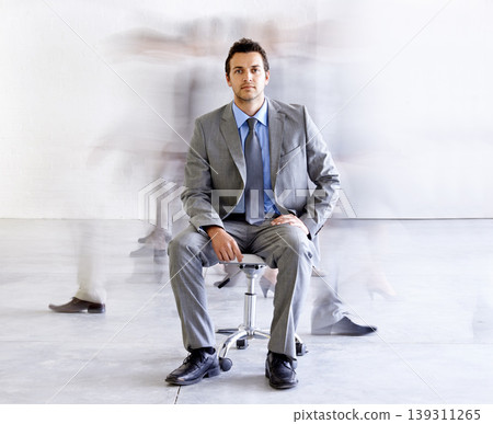 Portrait, chair and a corporate man in a busy office with motion blur people walking for company productivity. Work, business and professional with a young employee in a suit sitting in the workplace Portrait, chair and a corporate man in a busy office with motion blur people walking for company productivity. Work, business and professional with a young employee in a suit sitting in the workplace 139311265