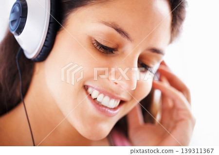 Headphones, face and happy woman listening to music playlist track, audio podcast or wellness sound. Closeup, happiness and relax person smile for media, song and streaming radio network 139311367