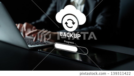 Cloud Backup Process in Progress with Laptop and Hands Typing on Black Desk Background in Modern Workspace Setting Ledger 139311422