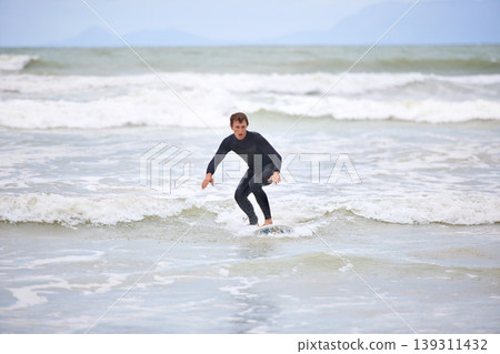 Surfer man, waves and board with balance, fitness and training for health, wellness and freedom in summer. Person, surfing and outdoor for sports, exercise and adventure at sea, ocean and sunshine Surfer man, waves and board with balance, fitness and training for health, wellness and freedom in summer. Person, surfing and outdoor for sports, exercise and adventure at sea, ocean and sunshine 139311432