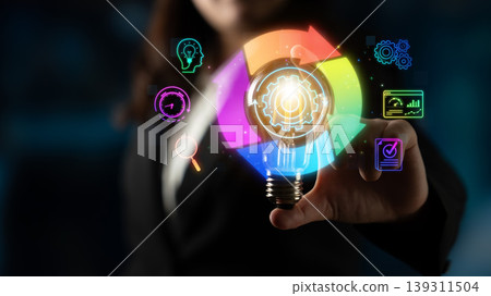 A businesswoman holds a light bulb illuminated with colorful icons, representing innovation and ideas in a modern workspace. Perfect for concepts of creativity and leadership. Sigmoid A businesswoman holds a light bulb illuminated with colorful icons, representing innovation and ideas in a modern workspace. Perfect for concepts of creativity and leadership. Sigmoid 139311504