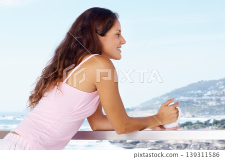 Happy, balcony and woman with coffee by ocean for summer holiday, vacation and weekend. Travel, hotel resort and person with warm drink for adventure, relaxing and freedom with scenic view of nature 139311586