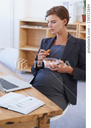 Business woman, pregnant and eating carrots for healthy diet, nutrition or food at office. Female person or employee in pregnancy or maternity with laptop and natural organic vegetables at workplace Business woman, pregnant and eating carrots for healthy diet, nutrition or food at office. Female person or employee in pregnancy or maternity with laptop and natural organic vegetables at workplace 139311684