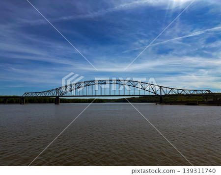 Steel Arch Bridge Spanning Calm River Under Blue Sky Scenic Waterfront Landscape Reflection Travel Infrastructure Landmark 139311740