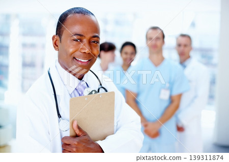Doctor, black man and portrait of clipboard with medical, healthcare and clinic staff in a hospital. Teamwork, job and stethoscope of a nurse and surgeon with professional team ready for working Doctor, black man and portrait of clipboard with medical, healthcare and clinic staff in a hospital. Teamwork, job and stethoscope of a nurse and surgeon with professional team ready for working 139311874