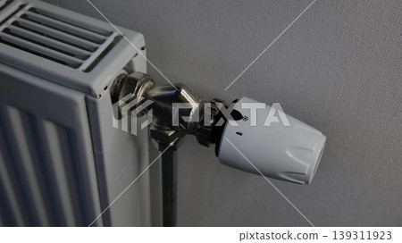 Close-up of a white radiator with a thermostatic valve for heating control Close-up of a white radiator with a thermostatic valve for heating control 139311923
