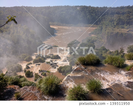 Aerial view of rocks, vegetation, and the turbulent river and Iguazu Falls in Iguazu National Park and Reserve in Argentina in June. Close-up. 139311950