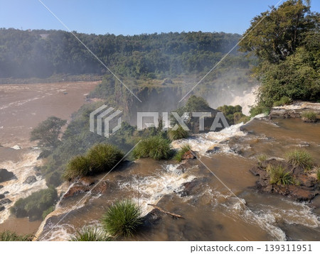 Aerial view of rocks, vegetation, and the turbulent river and Iguazu Falls in Iguazu National Park and Reserve in Argentina in June. 139311951