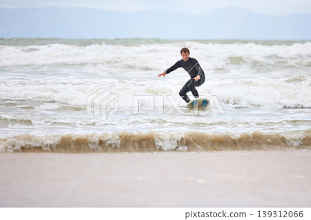 Surfer man, ocean and board with balance, fitness and training for health, wellness and freedom in summer. Person, surfing and outdoor for sports, exercise and adventure at sea, waves and sunshine Surfer man, ocean and board with balance, fitness and training for health, wellness and freedom in summer. Person, surfing and outdoor for sports, exercise and adventure at sea, waves and sunshine 139312066