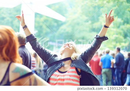 Woman, dancing and happy outdoor at music festival for freedom, performance and entertainment with crowd. Person, cheering and smile at event, concert or show with audience in nature for summer party Woman, dancing and happy outdoor at music festival for freedom, performance and entertainment with crowd. Person, cheering and smile at event, concert or show with audience in nature for summer party 139312070