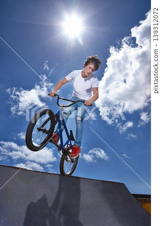 Ride, bike and teenager on ramp for sport performance, jump or training for event at park with blue sky mockup. Bicycle, stunt or balance on edge of board in trick for cycling competition challenge Ride, bike and teenager on ramp for sport performance, jump or training for event at park with blue sky mockup. Bicycle, stunt or balance on edge of board in trick for cycling competition challenge 139312072