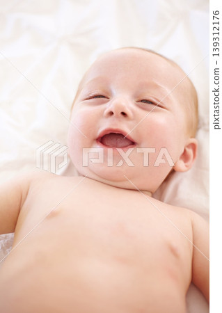 Happy baby on bed, funny and top view of young child in development, innocent or relax at home. Kid smile above, infant laughing in nursery and rest in bedroom, healthy body or skin, cute or adorable 139312176