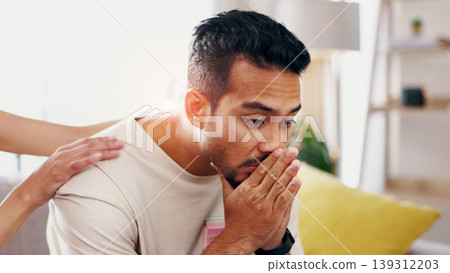 Hands, support and man with grief in home, heartbroken or thinking of divorce on sofa in living room. Comfort, help and person with depression after separation, reflection and sad memories in house Hands, support and man with grief in home, heartbroken or thinking of divorce on sofa in living room. Comfort, help and person with depression after separation, reflection and sad memories in house 139312203