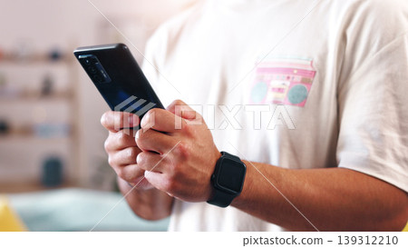Man, hands and home with phone for social media, network connection or online app subscription. Male person, user or blogger with mobile smartphone for chatting, texting platform or vlog in house 139312210
