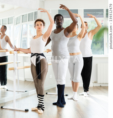 Group of men and women will learn to stand in third position during ballet rehearsal Group of men and women will learn to stand in third position during ballet rehearsal 139312479