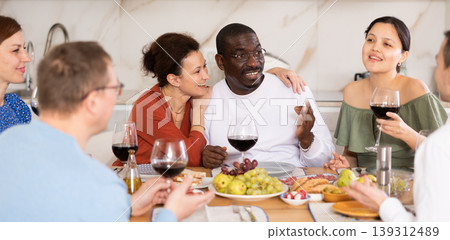 Multiethnic women and men friends chatting and drinking 139312489