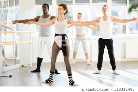 Group of men and women stand in second position 139312493