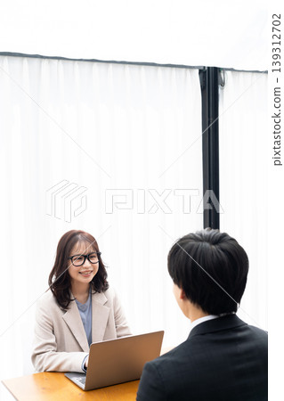 一位年輕女子正在給一位穿著西裝的男士提供建議。 139312702